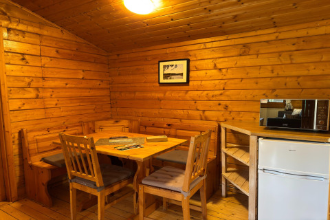 Knus houten lodge-interieur in Type C House 363 364 361 362 Duitsland, met eetruimte en kitchenette.