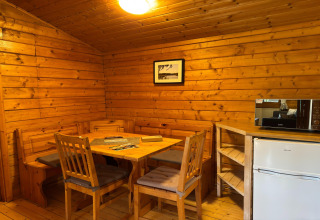 Gezellig houten lodge-interieur bij Type C House 363 364 361 362 in Duitsland, met eethoek en keukenblok.