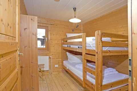 Houten kamer met stapelbedden en stoel in Type C House 363 364 361 362 lodge in Duitsland.