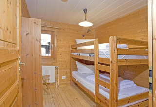 Houten kamer met stapelbedden en stoel in Type C House 363 364 361 362 lodge in Duitsland.