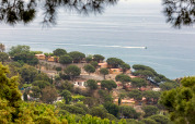Udsigt over Camping Rocagrossa Mobile Home omgivet af grønne træer med havet i baggrunden i Spanien.