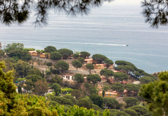 Blick auf Camping Rocagrossa Mobile Home mit Pinienbäumen und herrlichem Meerblick in Spanien.