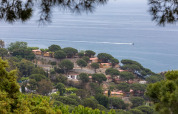Udsigt over Camping Rocagrossa Mobile Home omgivet af grønne træer med havet i baggrunden i Spanien.