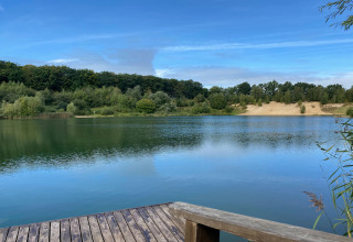 Uitzicht vanaf een houten terras op een rustig meer bij Type C House 363 364 361 362 in Duitsland.