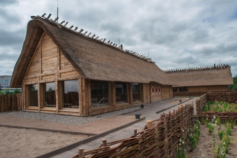 Traditionele lodge met rieten dak en houten frame, buitenaanzicht, Nurdachhaus Saver 65 m², Duitsland.