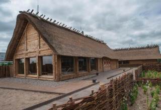 Traditional thatched-roof lodge with wooden frame, exterior view, Nurdachhaus Saver rate 65 sqm, Germany.