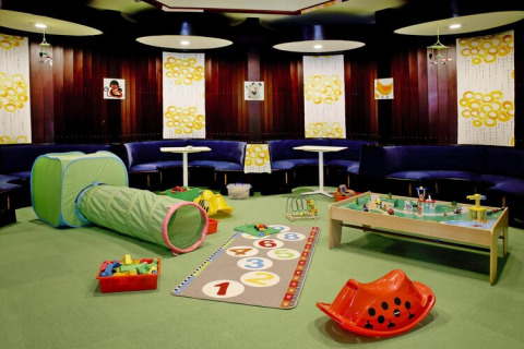 Speelruimte voor kinderen met speelgoed, speelmat, tunnel en speeltafel in een Duitse lodge.