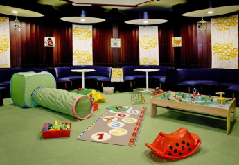 Kinderhoek met speelgoed, kruiptunnel en speelmat in een lodge in Duitsland.