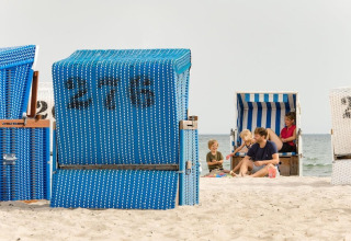 Gezin geniet van het strand voor strandstoelen bij Nurdachhaus Saver rate 65 m² in Duitsland.