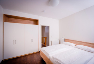 Moderne slaapkamer in Ostseeresort Dampland-Terrace house HiPr, Duitsland, met tweepersoonsbed en kast.