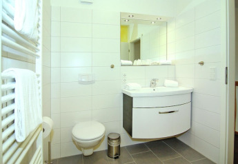 Modern badkamerinterieur bij Ostseeresort Dampland-Terrace house HiPr in Duitsland met toilet en wastafel.