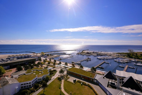 Uitzicht op zee vanaf Ostseeresort Dampland-Terrace house HiPr in Duitsland, met jachthaven en boten in zon.