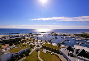 Vista mare dall'Ostseeresort Dampland-Terrace house HiPr in Germania, con porto turistico e barche al sole.