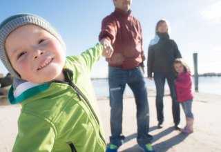 Blije familie geniet van een zonnige stranddag bij Ostseeresort Dampland-Terrace house HiPr in Duitsland.