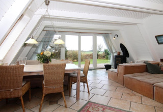 Acogedora sala y comedor en la casa vacacional Damp de 90 m² para 5 personas en Alemania, con vista al jardín.