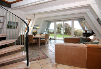 Luminoso salón moderno del Holiday home «Damp 90 sqm 5 Persons» en Alemania, con vista al jardín y escalera de caracol.