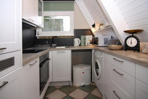 Cocina moderna y compacta en la casa de vacaciones «Damp 90 sqm 5 Persons» en Alemania con electrodomésticos.