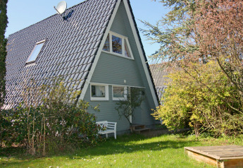 Maison en A avec toit sombre et jardin à Holiday home «Damp 90 sqm 5 Persons» en Allemagne.