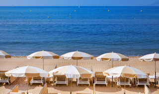 Tumbonas y sombrillas en una playa de arena cerca de Roquebrune-sur-Argens, Provenza-Alpes-Costa Azul, Francia.