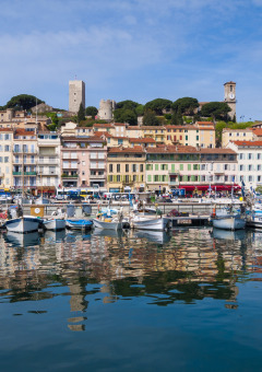 Barcos coloridos y casas históricas reflejadas en el puerto cerca de Roquebrune-sur-Argens, Provenza, Francia.