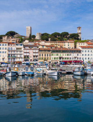 Barcos coloridos y casas históricas reflejadas en el puerto cerca de Roquebrune-sur-Argens, Provenza, Francia.
