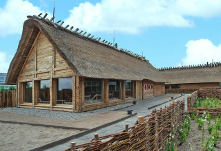 Casa tradizionale dal tetto di paglia con grandi finestre e recinzione intrecciata, Blockhouse ‘HiPr 4 Pers’ in Germania.