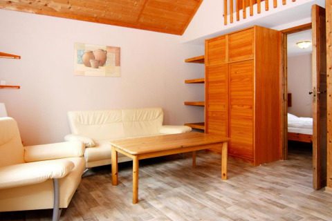 Living room at Holiday park 'Markgrafenheide Warnemünde Type 1' in Germany with light furniture decor.