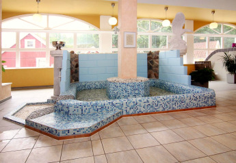 Indoor spa area with tiled pool, water fountain and statue at Holiday park Markgrafenheide Warnemünde, Germany.