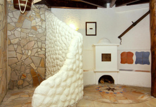 Rustic lodge interior at Holiday park Markgrafenheide Warnemünde, featuring stone walls and a unique oven.