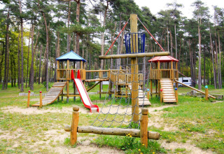 Houten speeltuin met glijbaan en klimnet bij Holiday park Markgrafenheide Warnemünde in Duitsland.