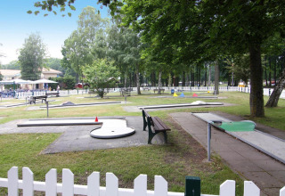 Outdoor mini golf course at Holiday park Markgrafenheide Warnemünde in Germany, surrounded by trees.