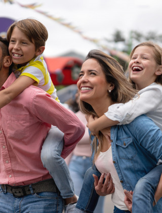 Glückliche Familien genießen Aktivitäten im Freien in einem Ferienpark mit Glamping-Unterkünften und Zelten.
