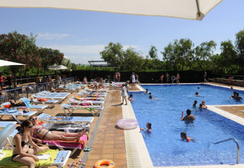 Zwembad bij Camping del Mar MOBILE HOME 6P in Spanje, met zonnebadende gasten en spelende kinderen.
