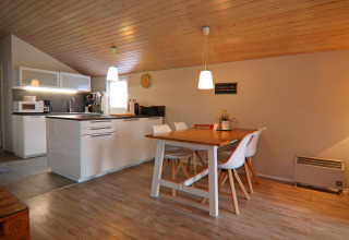 Cucina e sala da pranzo moderne con soffitto in legno nella casa vacanze «in Hünning» in Germania, atmosfera accogliente.