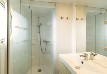 Baño móvil en Camping del Mar MOBILE HOME 6P, España, con ducha, lavabo, espejo y percheros.