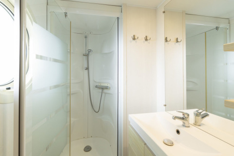 Baño móvil en Camping del Mar MOBILE HOME 6P, España, con ducha, lavabo, espejo y percheros.