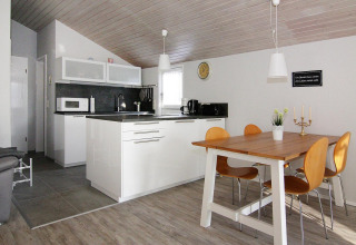 Cucina moderna e zona pranzo luminosa con arredi in legno all’Holiday home «in Hünning» in Germania.