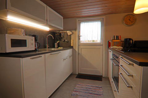 Cocina moderna en la casa de vacaciones «in Hünning» con muebles blancos y electrodomésticos, Alemania.