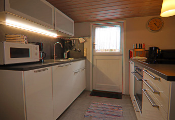 Cocina moderna en la casa de vacaciones «in Hünning» con muebles blancos y electrodomésticos, Alemania.