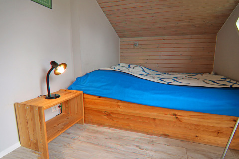 Et hyggeligt soveværelse i Holiday home «in Hünning» i Tyskland med enkeltseng og trænatbord.