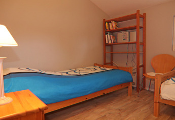 Chambre confortable au Holiday home à Hünning en Allemagne avec deux lits, étagère et chaise.
