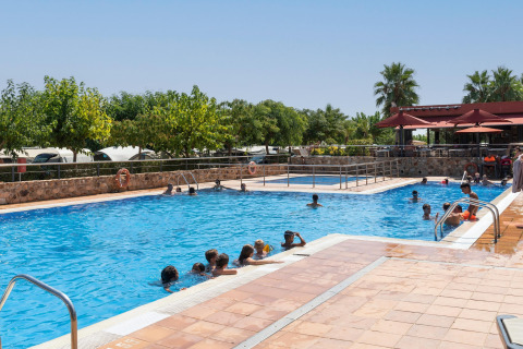 Familien und Kinder genießen einen sonnigen Tag im Pool des Camping del Mar BUNGALOW PREMIUM in Spanien.