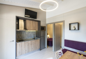 Cocina y comedor modernos en Camping del Mar Bungalow Premium, España, con dormitorio visible al fondo.