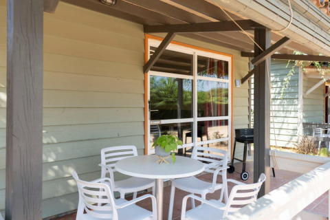 Terrasse beim Camping del Mar BUNGALOW PREMIUM in Spanien mit Tisch, Stühlen und Grill.