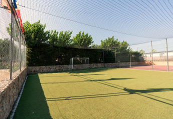 Kleines Fußballfeld mit Kunstrasen im Camping del Mar BUNGALOW PREMIUM in Spanien, umzäunt und sonnig.