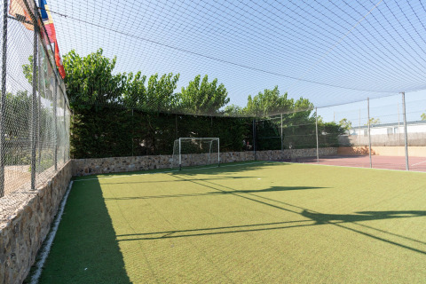 Kleines Fußballfeld mit Kunstrasen im Camping del Mar BUNGALOW PREMIUM in Spanien, umzäunt und sonnig.