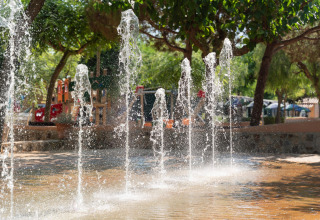 Wasserfontänen auf einem schattigen Spielplatz beim Camping del Mar BUNGALOW PREMIUM in Spanien.