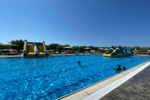 Udendørs swimmingpool ved Els Pins Mobile-Home Plus 2 i Spanien, med oppustelige vandrutsjebaner og gæster.