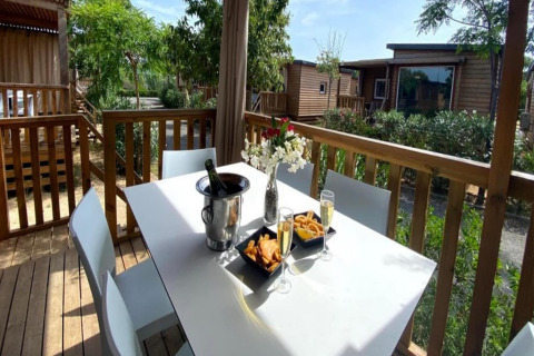 Udendørs terrasse ved Els Pins - Mobile-Home Plus 2 i Spanien, med bord, drikke og snacks.