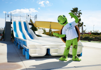 Mascota de tortuga posando junto a toboganes acuáticos en Els Pins Mobile-Home Plus 3, España, al aire libre.